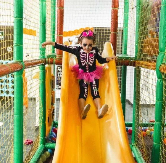 Niña disfrazada de esqueleto en el parque de bolas de Magic Natura en Halloween