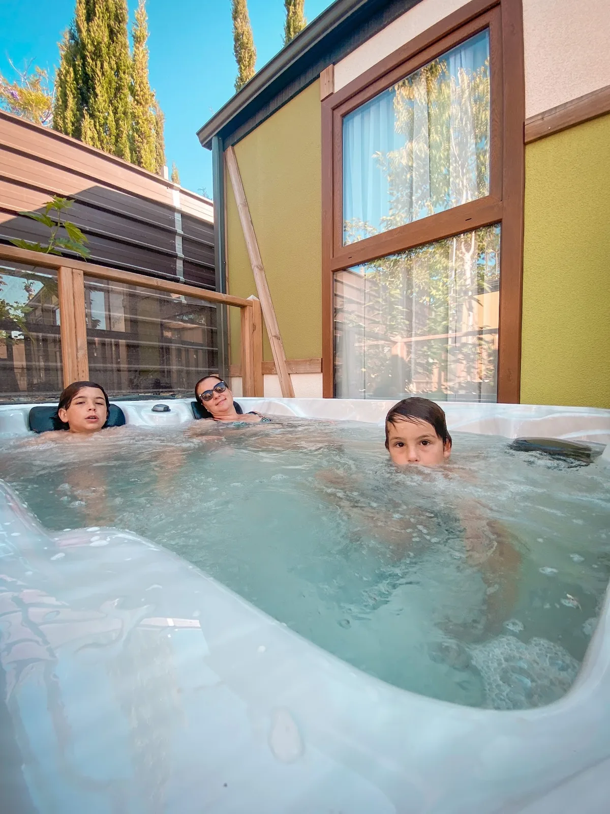Familia disfrutando del jacuzzi privado de la cabaña en Magic Robin Hood